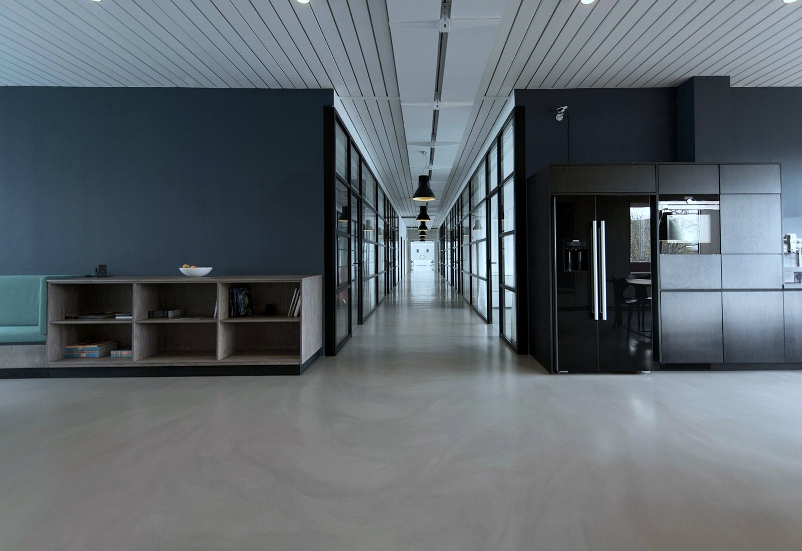 Clean commercial office corridor with glass partitions and a polished floor