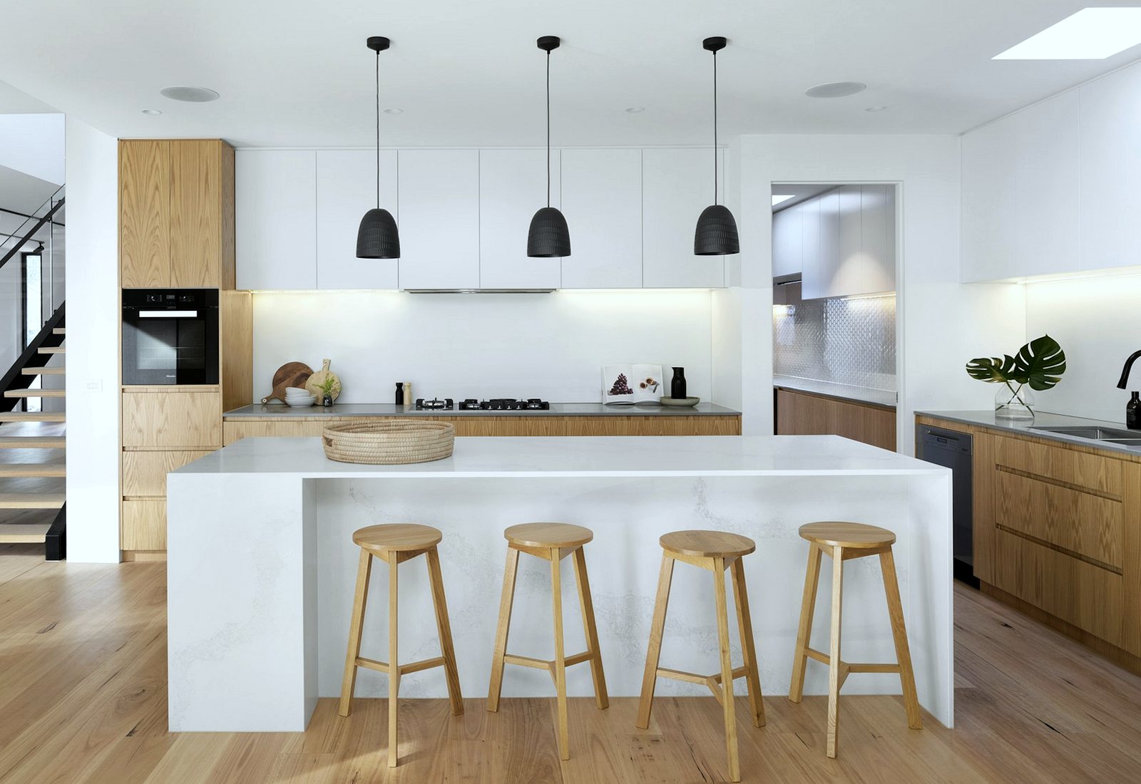Clean domestic kitchen with a white island and wooden cabinets